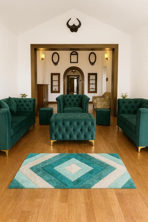 a living room with two green couches and a rug at Secret Escape Colonial Bungalow in Ooty