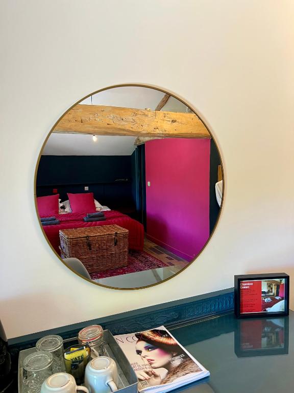 a mirror on a wall with a room with a bed at La Rive Chambre d hôtes The Riverside Retreat in Jarnac