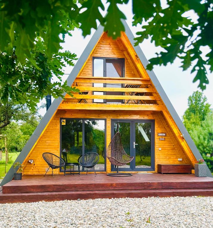 a cabin with a triangular roof with chairs and windows at CASA MAYA Câmpulung in Câmpulung