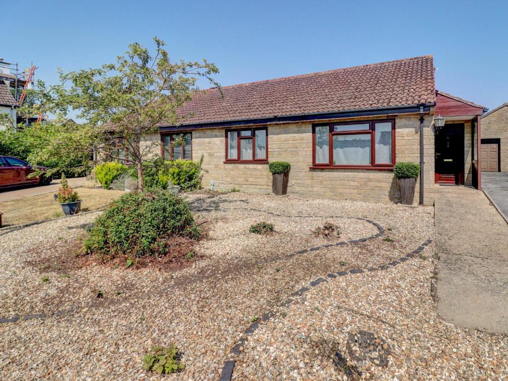 a house with a gravel driveway in front of it at Dorset Escape in Gillingham
