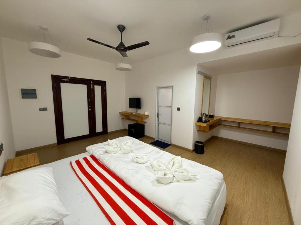 a bedroom with a bed with a red and white blanket at Piyo in Thoddoo