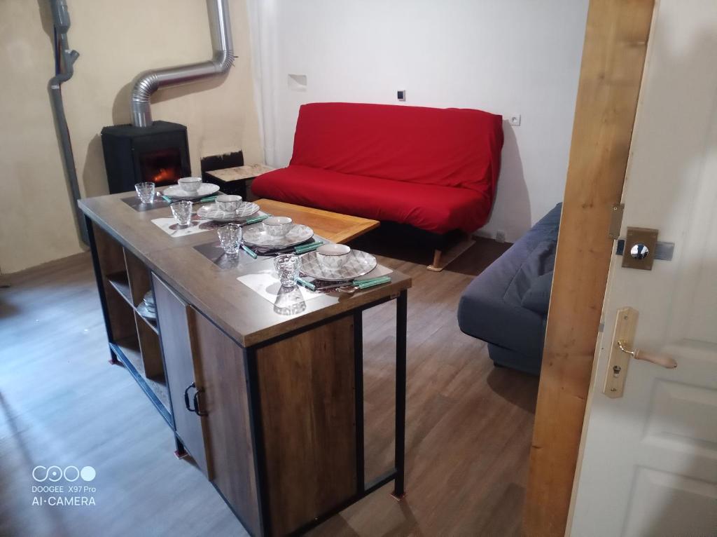 a room with a table with glasses and a couch at De particulier à particulier in Mauléon-Barousse