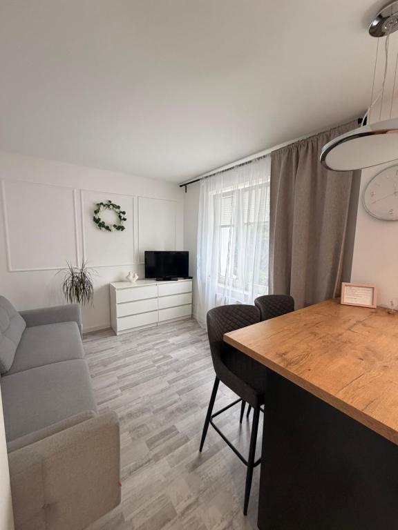 a living room with a dining room table and a couch at Apartament Modrzewia in Elblag