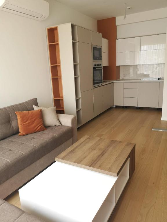a living room with a couch and a kitchen at AH Home Delux Centar in Sarajevo
