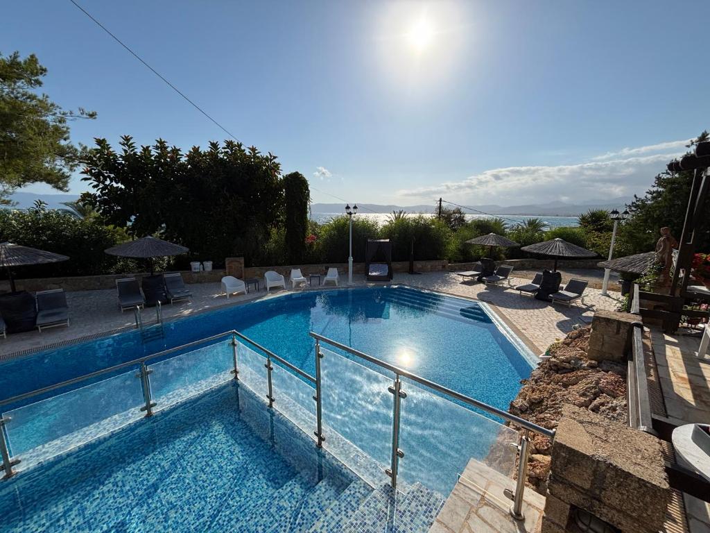 a large blue swimming pool with chairs and umbrellas at Villas Vista Del Mar in Kissamos