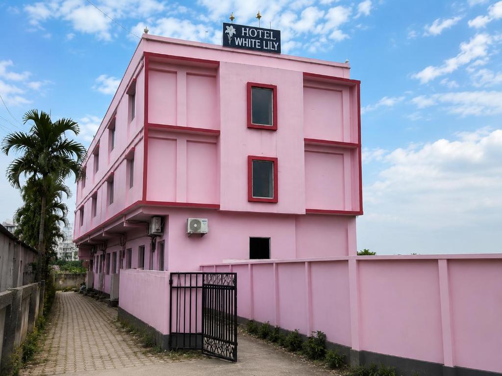 a pink building with a sign on top of it at White Lily in Guwahati