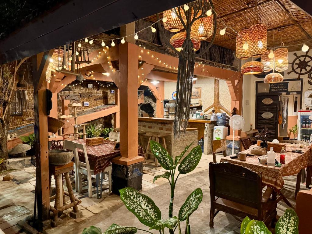 a restaurant with tables and chairs and potted plants at Alianna Homestay in Karimunjawa