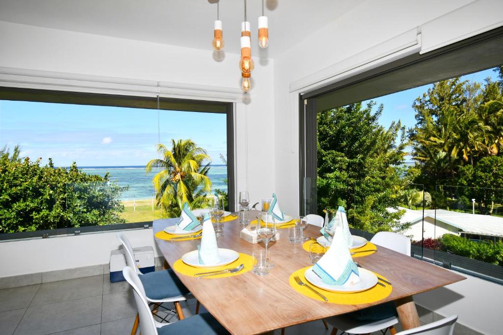 a dining room with a table and a view of the ocean at Le Bergamote in Riambel