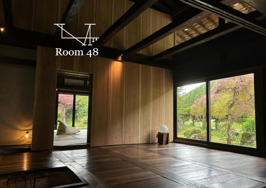 ein Zimmer mit Holzvertäfelung und ein Zimmer mit einem großen Fenster in der Unterkunft Room 48 in Takayama