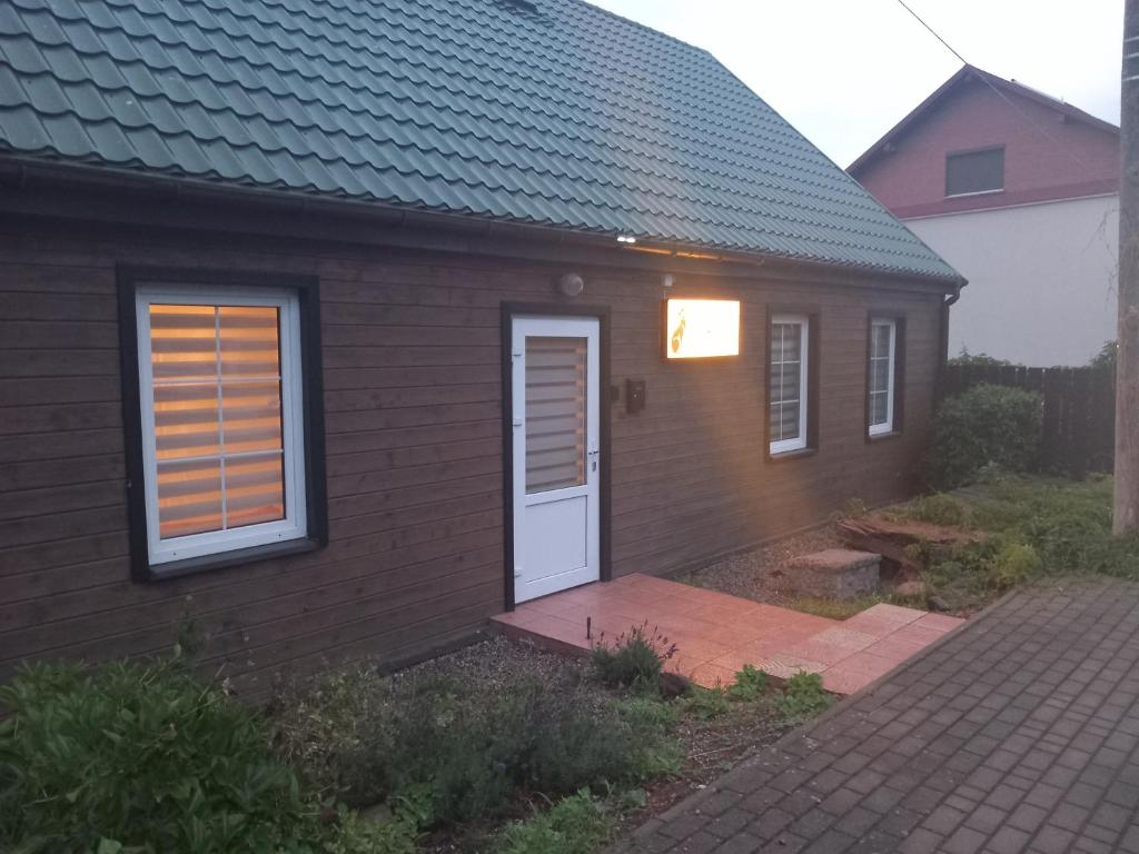 a brown house with a white door and a porch at Noclegi Puńsk w centrum 50 m in Puńsk