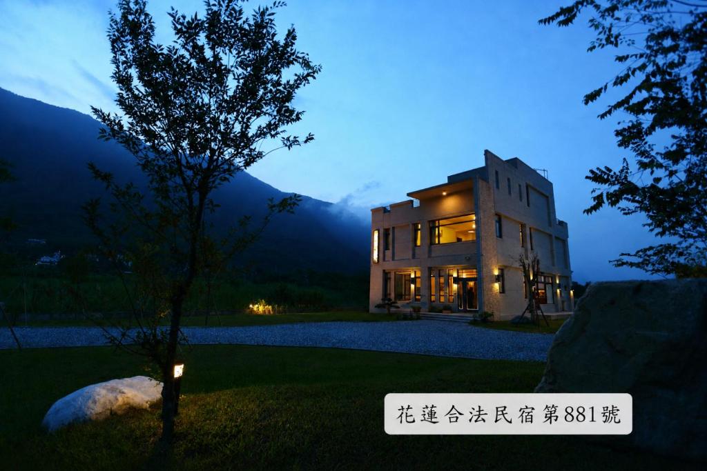a building at night with a tree in front of it at Qian B&B in Jiamin