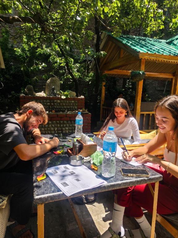 a group of people sitting around a picnic table at Purnima Little Italy in Manāli