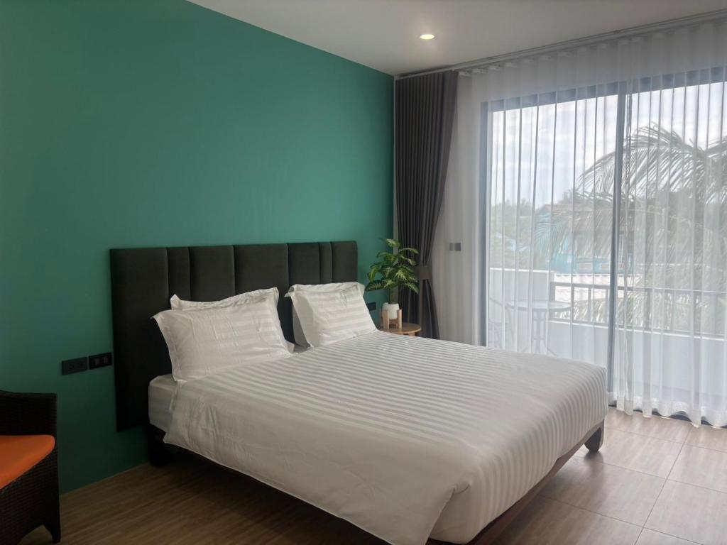 a bedroom with a large bed and a large window at The Hidden Place Bangtao in Bang Tao Beach
