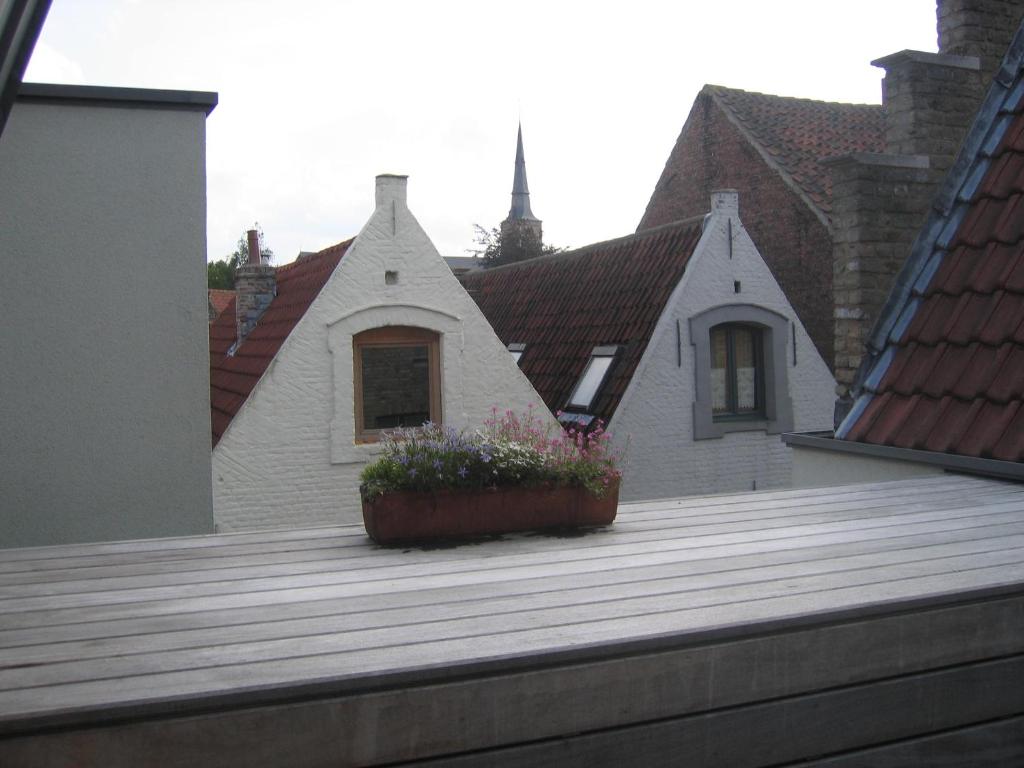 a house with a wooden deck with a flower pot at B&B 't Walleke in Bruges