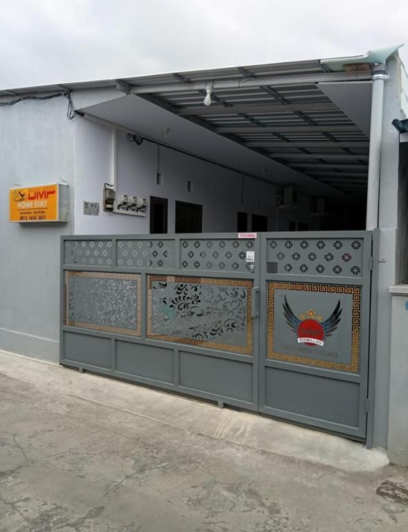 a building with a gate with a sign on it at DMP Homestay in Ketapang