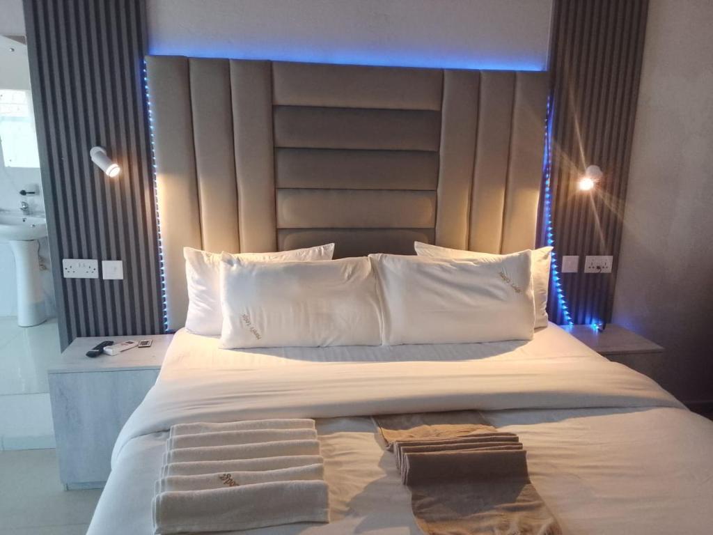 a bedroom with a large bed with a blue light above it at Munjiz Lodge in Livingstone