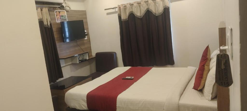 a hotel room with a bed and a television at HoTEL RAJ VIHAR RESIDENCY in Vijayawāda