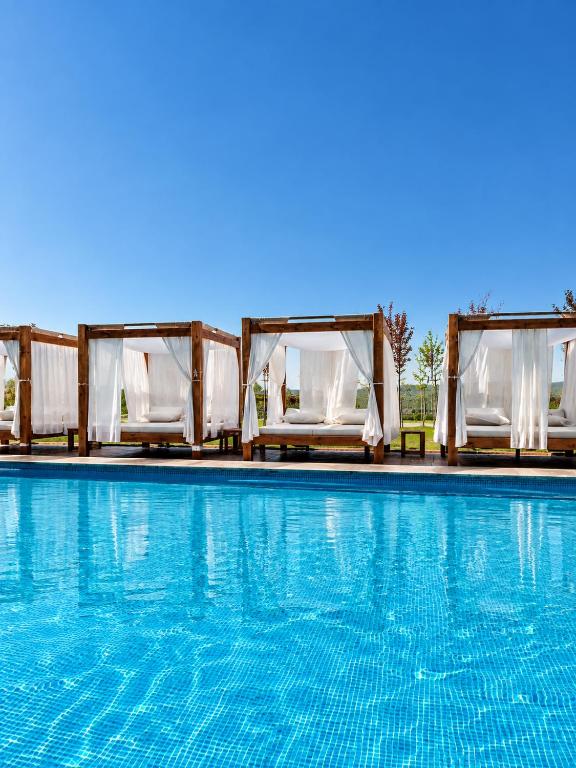 a swimming pool with white chairs and a swimming pool at Deluxe Mountain View Studio ViS in Residence Hill Hotel Kopaonik in Kopaonik