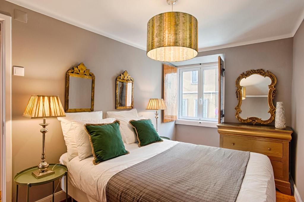 a bedroom with a large bed with green pillows at River View Alfama Historic Lisbon in Lisbon