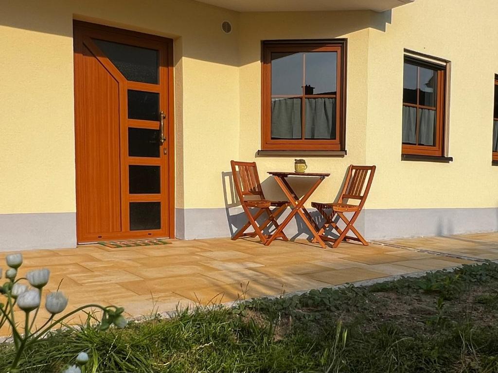 a patio with two chairs and a table in front of a house at Appartement Mari Lou in Ebermannstadt