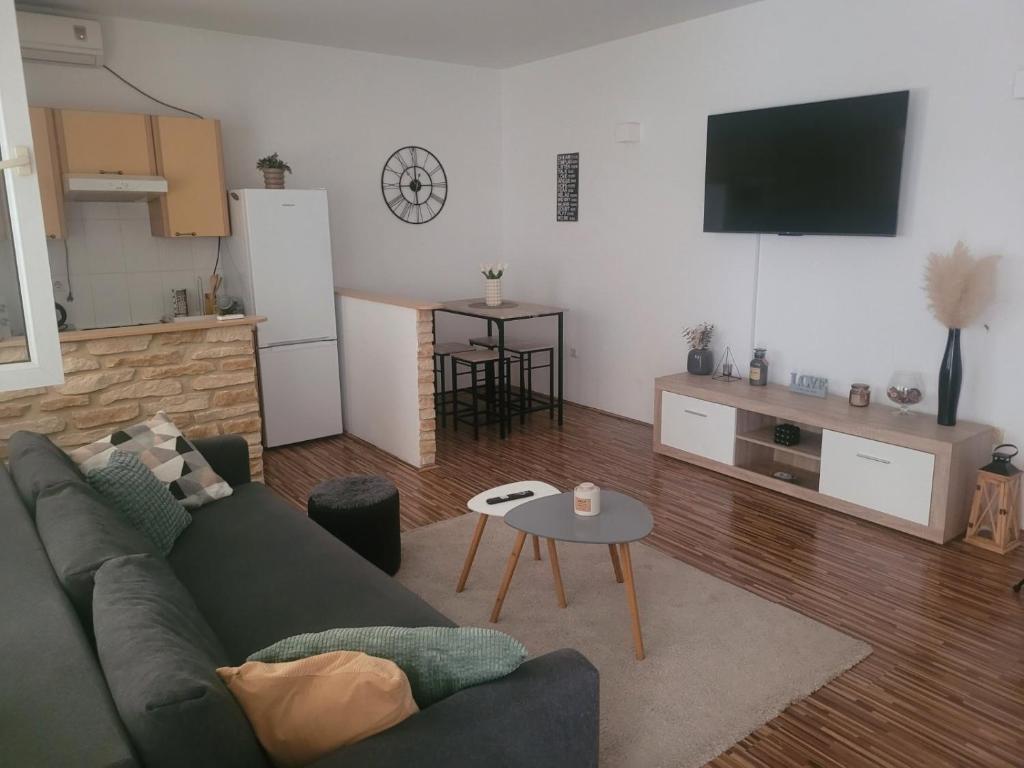 a living room with a green couch and a table at Apartment Laura & Lucija in Osijek