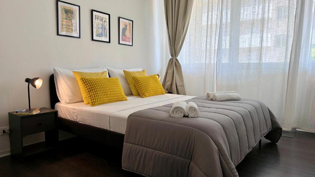 a bedroom with a bed with yellow pillows and a window at The Yellow Corner in Pasian di Prato