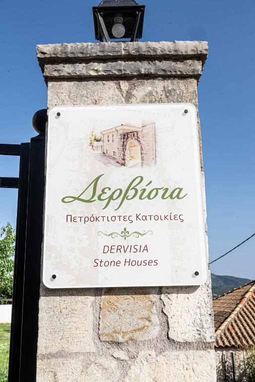 a sign for a restaurant on a stone wall at Dervisia Stonehouse 3 in Lazaráta