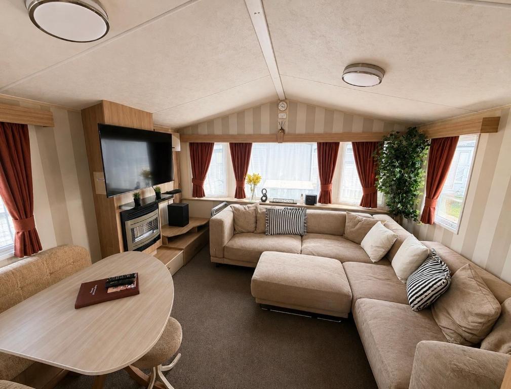 a living room with a couch and a table at Seaside Escape at St Osyth in Clacton-on-Sea
