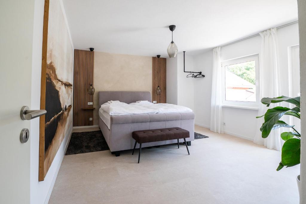 a bedroom with a bed and a stool in it at La Casa Demi in Hetzerath