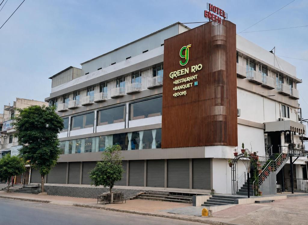 a building with a greenrosis sign in front of it at hotel green rio in Ahmedabad