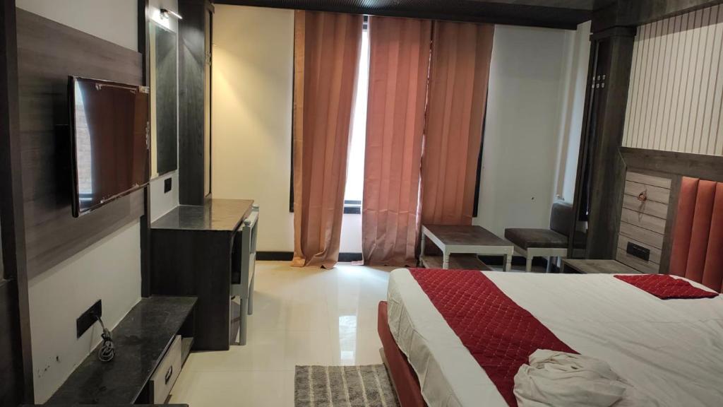 a hotel room with a bed and a flat screen tv at Hotel bindu in Ghāzīpur