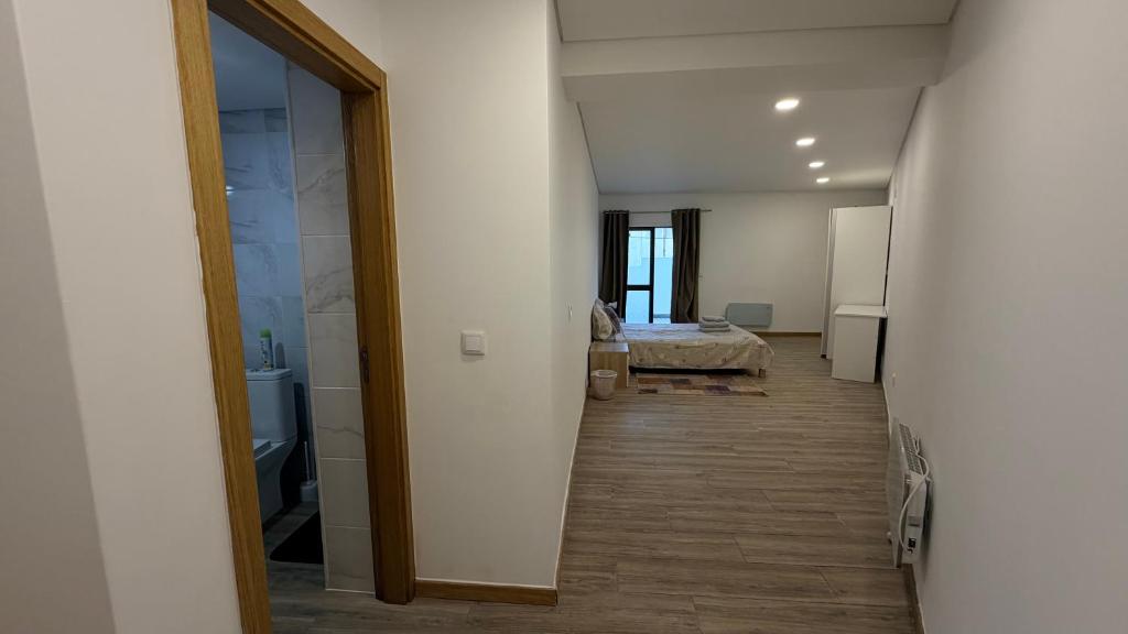 a hallway leading to a bedroom with a bed in a room at Quarto privado com banheiro no centro de Viseu in Viseu