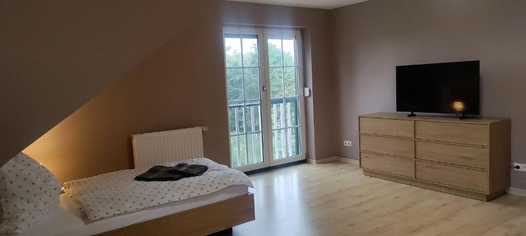 a bedroom with a bed and a television on a dresser at Monteurwohnung - Zimmer in Tarmow