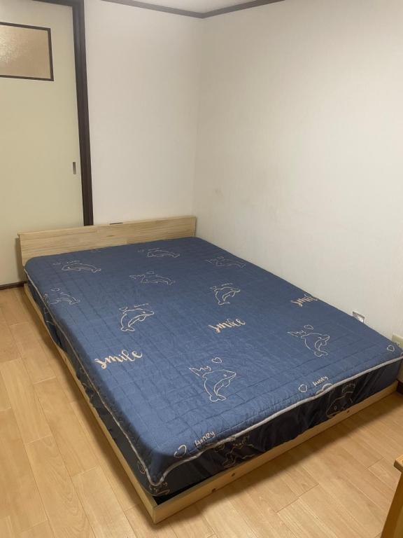 a bed sitting in a room with a blue mattress at 大阪魔力民泊·岸里 in Osaka