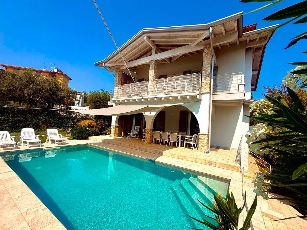a house with a swimming pool in front of it at Villa Bocciolo, piscina, giardino, vasca idromassaggio in Manerba del Garda