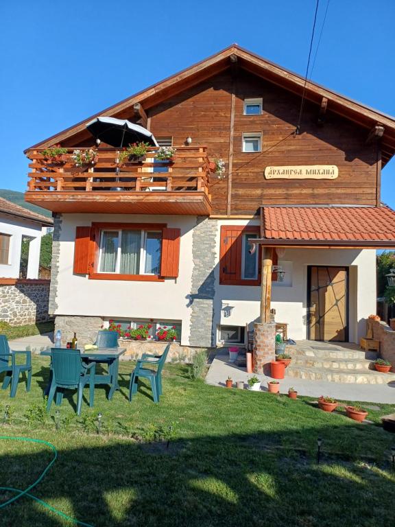 a house with a table and chairs in the yard at Стаи за гости "Архангел Михаил" in Kostenets