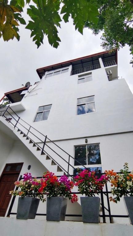 a white building with flowers in front of it at River Line -Ella in Ella