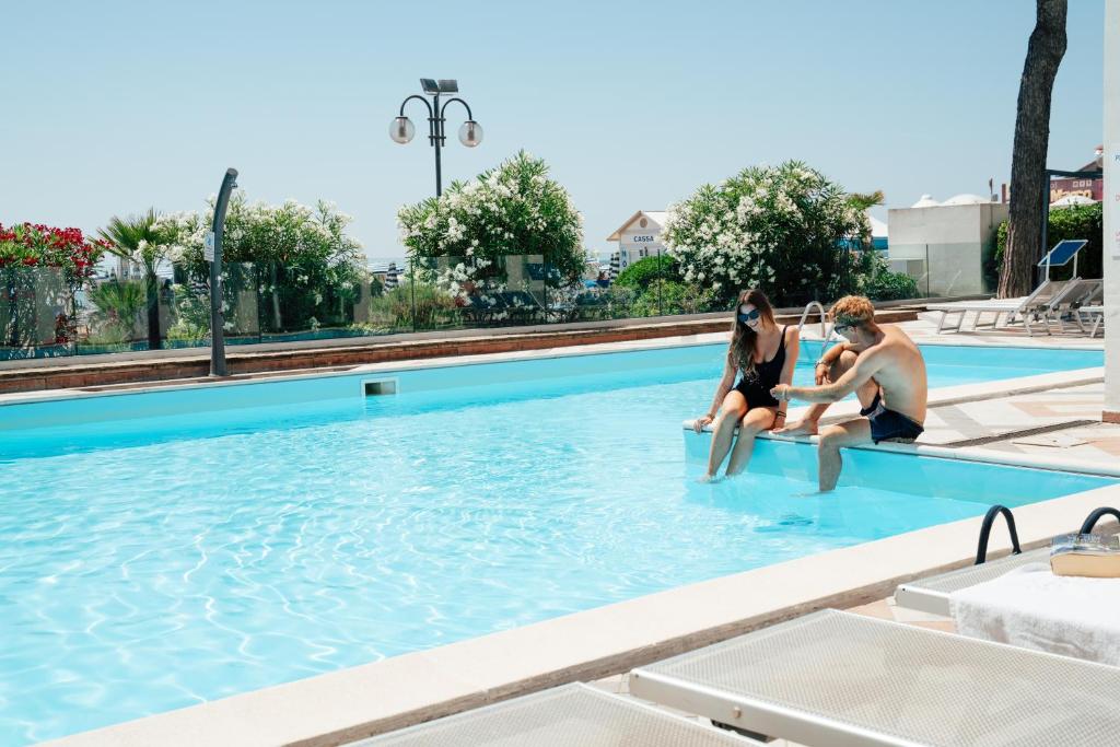 a group of three women sitting in a swimming pool at Hotel Niagara in Lido di Jesolo