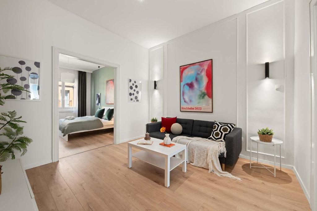 a living room with a black couch and a table at Chic 2BR Loft Steps from Great Synagogue Budapest in Budapest