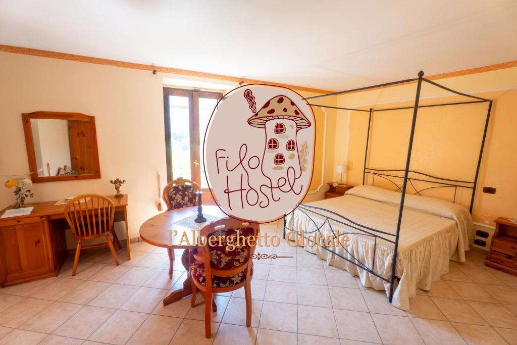 a bedroom with a bed and a desk and a table at Filohostel l'Albergo Glocale in Sant'Agata de' Goti