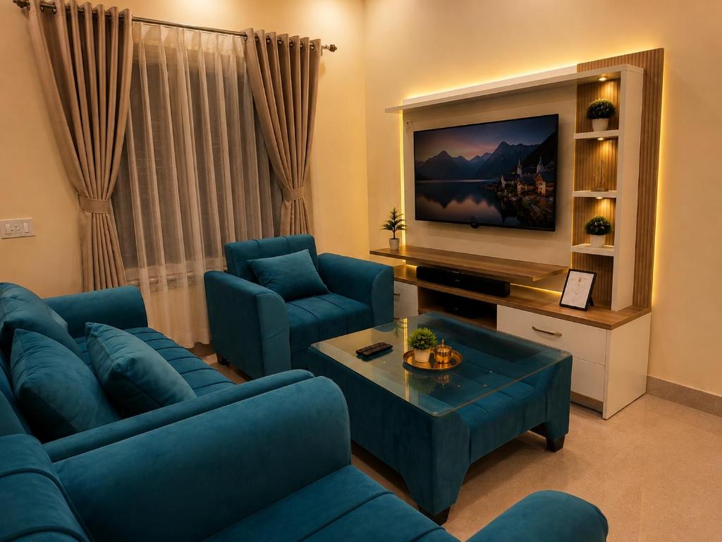 a living room with blue couches and a tv at Flying Suites Newtown in kolkata