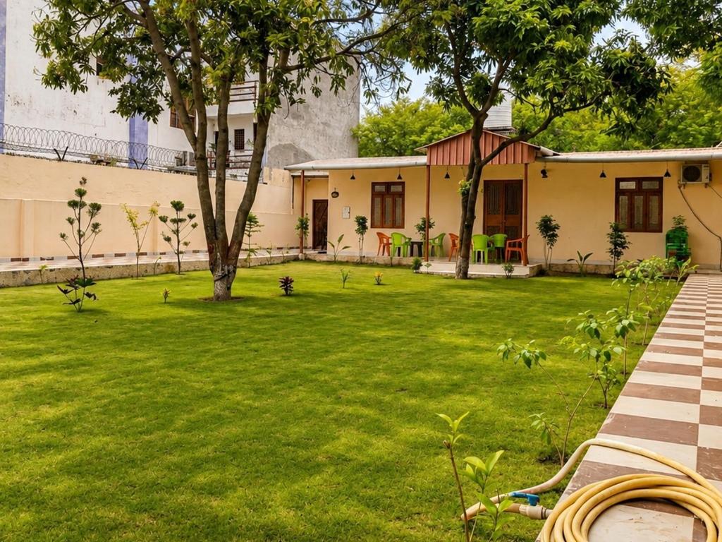 a green yard with a building and a tree at A2 Villa by JMD - Peaceful Stay Near Expo Mart in Greater Noida