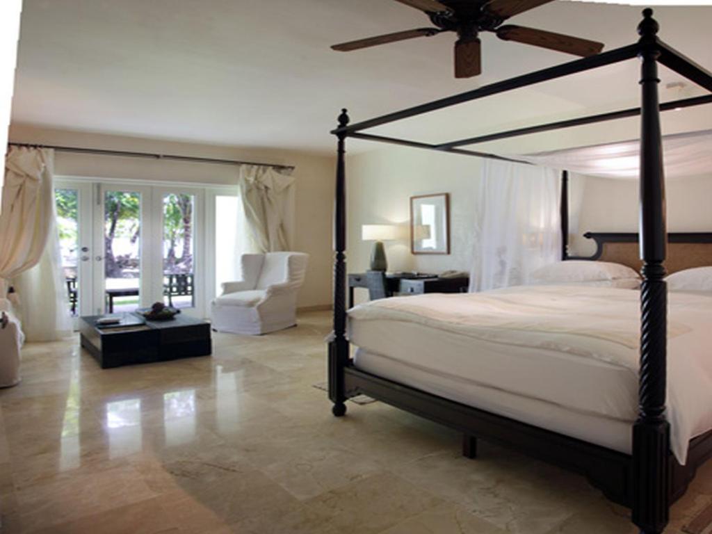 a bedroom with a large bed with a ceiling fan at Casa Colonial Beach & Spa in San Felipe de Puerto Plata