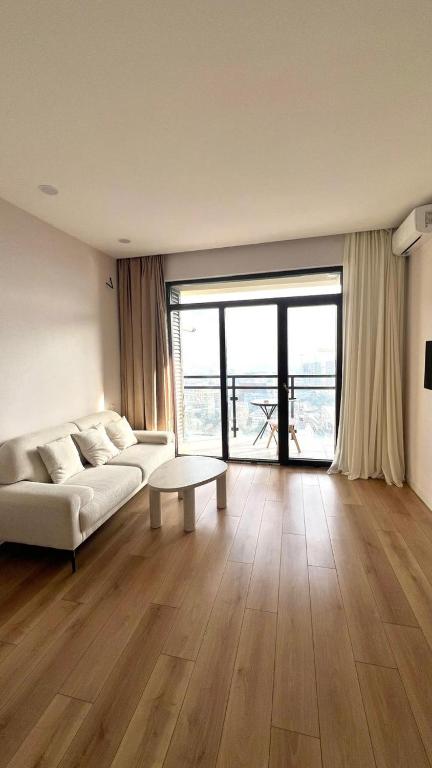 a living room with a white couch and a table at 21 floor apartment in Tbilisi City