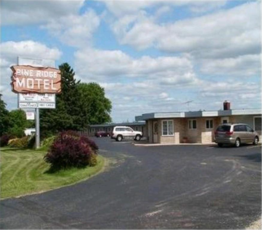 una señal para un motel en un estacionamiento en Pine Ridge Motel, en Dodgeville