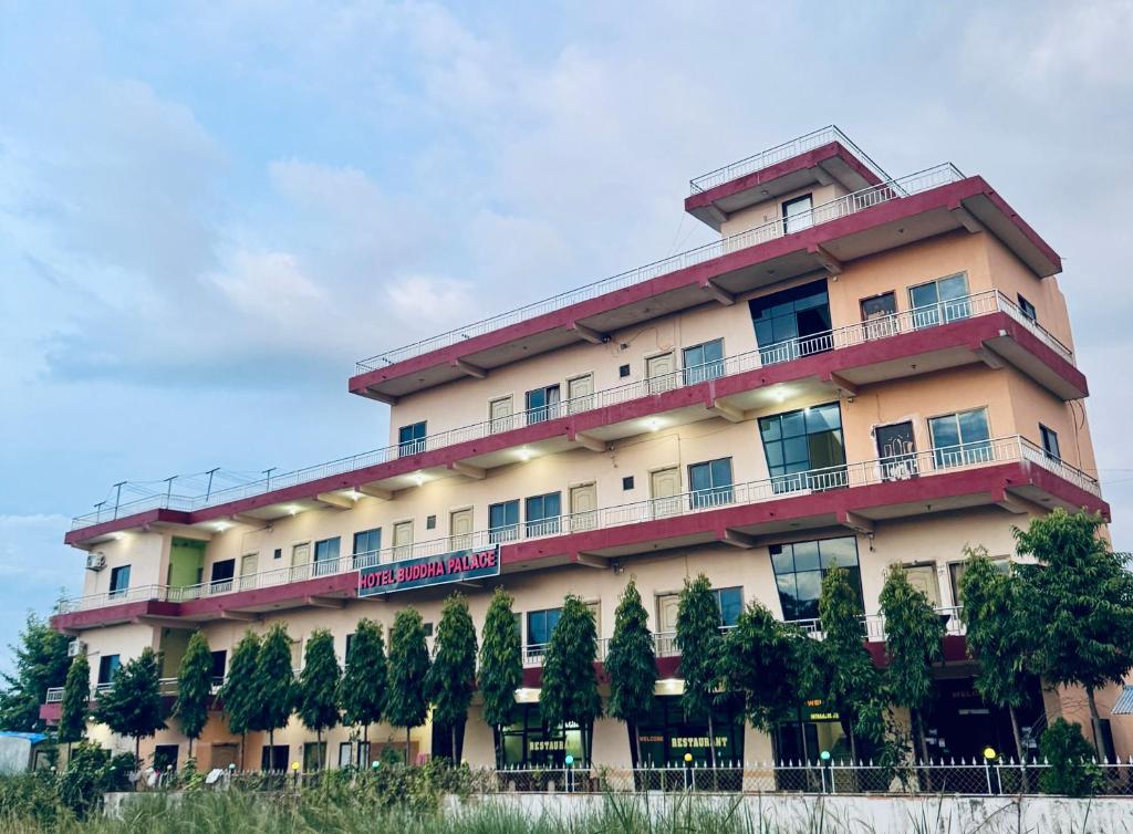 a large building with trees in front of it at Hotel Buddha Palace in Rummindei