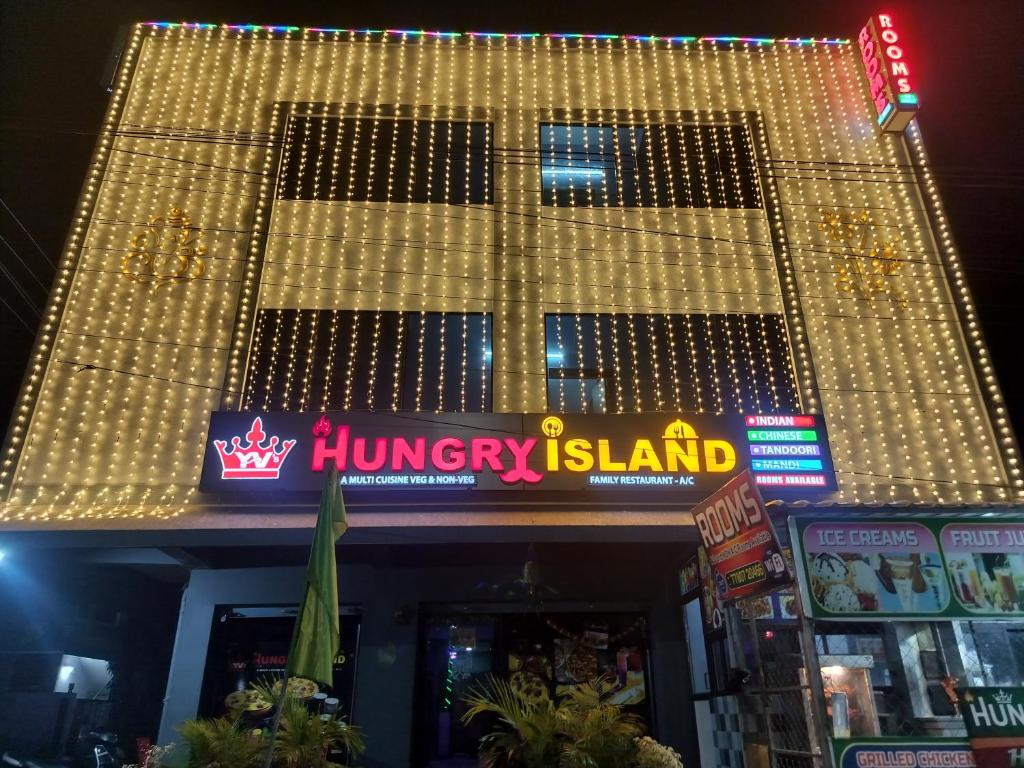 a hungry island restaurant with christmas lights on it at YVs Hungry island in Bāpatla