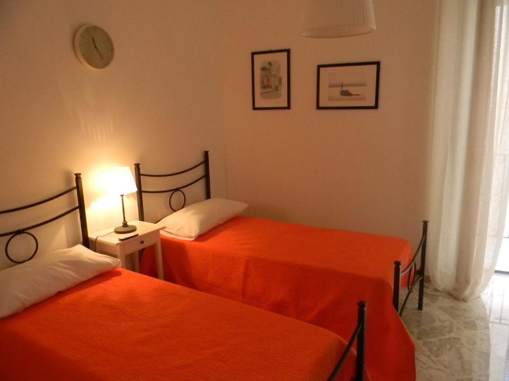 2 Betten in einem Zimmer mit orangefarbener Bettwäsche in der Unterkunft Casa Marylisa in Bari