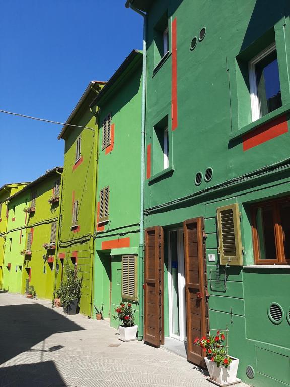 a group of buildings with green and yellow at B&B da Baba in Ghizzano