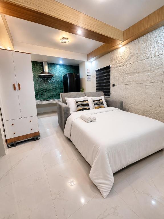 a bedroom with a large white bed and a couch at Lunan Boutique Hotel & Hostel in Taytay